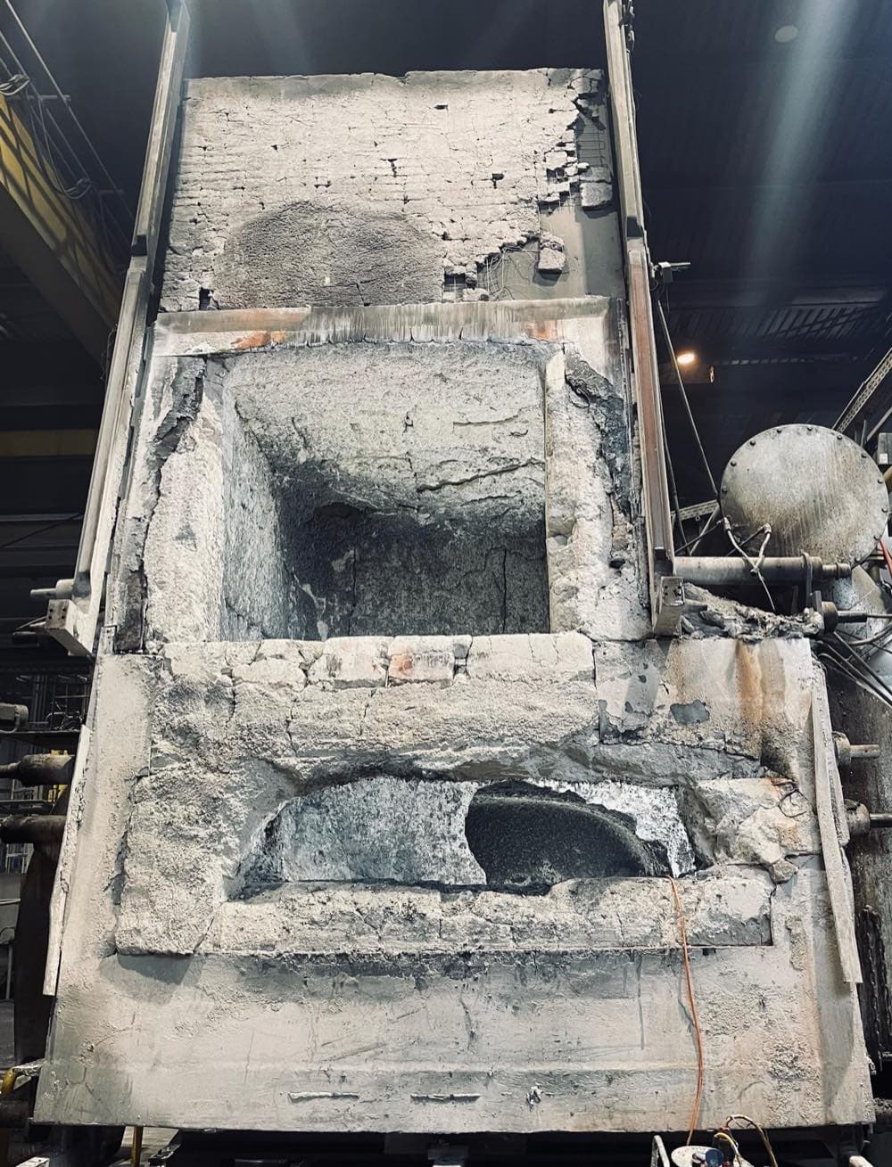 Türportal eines Aluminium-Schmelzofens vor der Reparatur mit großflächig ausgebrochenem Feuerfestmaterial