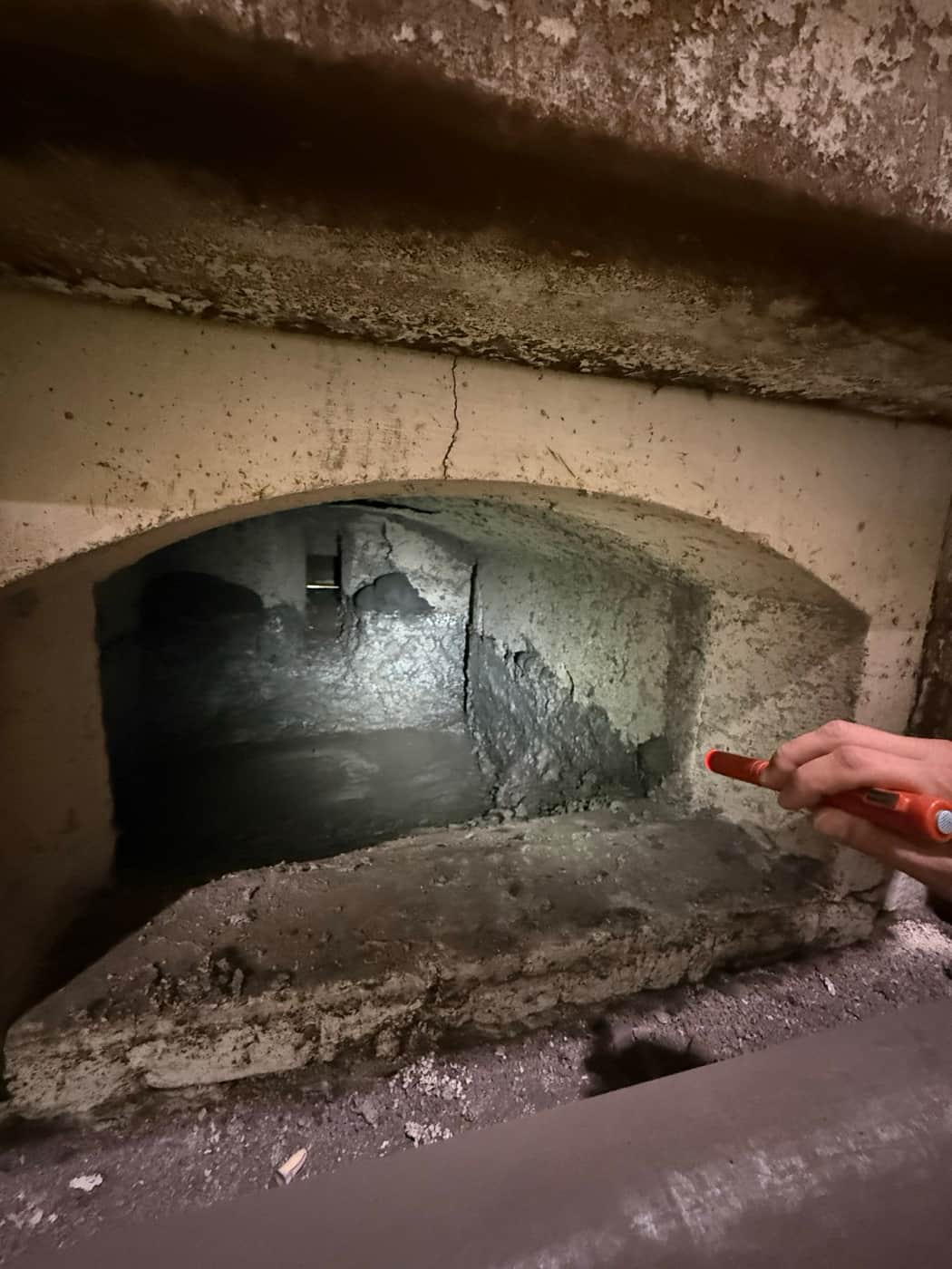 Regard à la lampe torche par l'ouverture du four dans une chambre de fusion usée lors d'une visite à l'arrêt