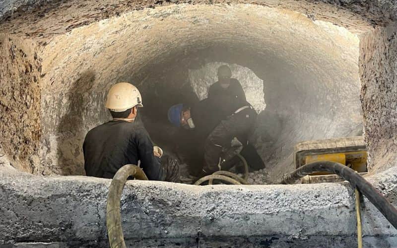 Skilled worker carrying out care spraying using the shotcrete process on an industrial furnace