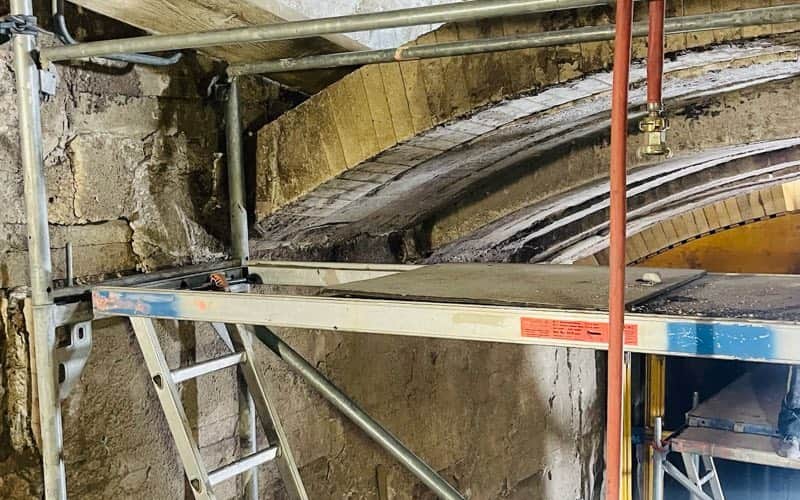 Gemauertes Ofengewölbe und Seitenwand mit freigelegten Ankerpunkten während einer Revision